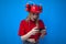 Surprised girl fan watching a game on a smartphone and rooting for her team, excited fan in red uniform using a phone on a blue