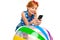 Surprised girl leans on an inflatable swimming ball and reads messages on the phone on a white studio background