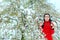 Surprised Girl By Snow Covering Spring Flowers in Blossoming Tree