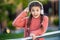 Surprised girl taking off headphones. Teenage girl holding headphones next to ear