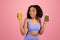 Surprised glad millennial african american woman in sportswear hold jars of juice or smoothies