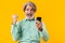 Surprised grey-haired bearded man using mobile phone