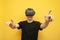 Surprised guy with VR glasses touches virtual space on a yellow background, using modern virtual reality gadgets