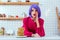 surprised housewife with purple hair and pancakes looking at camera and gesturing with hand