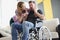 Surprised husband got news about wife pregnancy, middle aged man in wheelchair