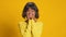 Surprised joyful ethnic woman looks surprisingly over yellow background