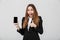 Surprised lady showing thumb up gesture and smartphone isolated