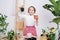 Surprised little girl demonstrating seedling with pot-shaped soil and roots