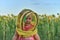 Surprised little girl wearing a beekeeper mask against the backdrop of a field with sunflowers. Beekeeping concept