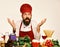 Surprised male chef or cook with beard near vegetables