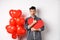 Surprised man holding Valentines heart card and saying wow, looking amazed at camera, receive secret confession on