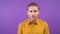 Surprised man looks closely at the camera. Young adult isolated on purple background. 4K