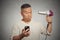 Surprised man reading social media news on phone holding hairdryer