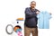 Surprised mature man holding a shrunken t-shirt in front of a washing macine