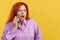 Surprised mature redheaded woman talking to the mobile