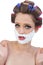 Surprised model in hair curlers posing with shaving foam