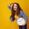 Surprised modern woman with clock looking into distance