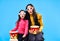 Surprised mother and her little daughter in 3D glasses with popcorn watching movie over blue background