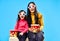 Surprised mother and her little daughter in 3D glasses with popcorn watching movie over blue background