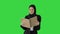 Surprised Muslim Businesswoman reading business diary and shaking her head while walking on a Green Screen, Chroma Key.