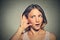 Surprised nosy woman hand to ear gesture carefully secretly listening