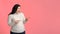 Surprised Plump Woman Pointing Aside At Copy Space On Pink Background