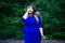 Surprised plus size fashion model in blue dress outdoors, beauty woman with professional makeup and hairstyle