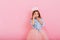 Surprised pretty young girl in tulle skirt with crown on head expressing isolated on pink background. Amazing cute