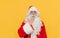 Surprised Santa Claus is touching his mouth with his hand showing an amazement gesture, feeling shocked, looking at the camera