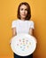 Surprised slim woman nutritionist holds a plate with different color tablet pills diet supplements prescription weight loss drugs