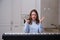 Surprised woman musician spread her hands in amazement looking at digital piano