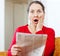 Surprised woman with newspaper