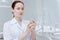 Surprised woman in white smock standing in dentist cabinet