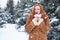 Surprised woman winter outdoor portrait, snowy fir trees background