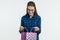 Surprised young woman looking shopping bag, white background