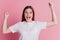 Surprised young woman rejoice astonished mood open mouth raise fists over pink background