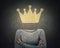 Surreal image young woman with crossed arms and crown symbol instead of head drawn over blackboard background. Business leadership