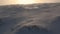 Surreal landscape of a snow covered mountain slope with sun radiating a orange glow and green moss showing through in scotland, ca