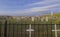 It is surrounded by a metal fence with white crosses. We see the gravestones as well as statues. Photo taken on a clear day,