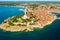Surroundings of Rovinj and tower of St. Euphemia church. Croatian town buildings near forests and Adrianic sea at bright