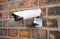 Surveilance CCTV camera on the red brick wall. 3d rendering illustration