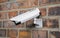 Surveilance CCTV camera on the red brick wall. 3d rendering illustration