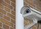 Surveillance Camera Closeup mounted on Yellow Brick Wall