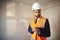 Surveyor In Hard Hat And High Visibility Jacket With Digital Tablet Carrying Out House Inspection