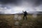 Survivor in gas mask and black jacket looks up at smoked sky. Post-apocalyptic air pollution. Nuclear war. Doomsday