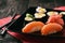 Sushi assortment with ginger and vasabi on black plate.