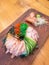 Sushi bagel served on a wooden board together with ginger, wasabi and horse reddish