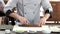 Sushi chef cutting smoked eel.