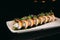 Sushi Chuka Roll on a white plate on a black background