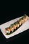 Sushi Chuka Roll on a white plate on a black background